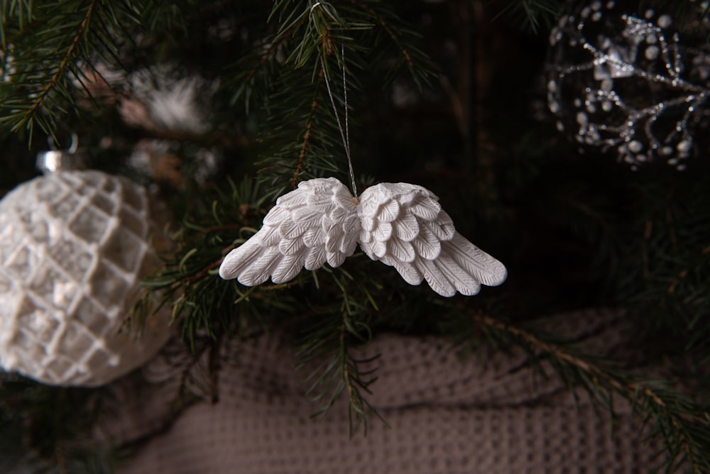 a white angel ornament hanging from a christmas tree