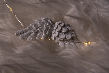 Serene lavender and silver angel wings softly glowing against a misty violet background.