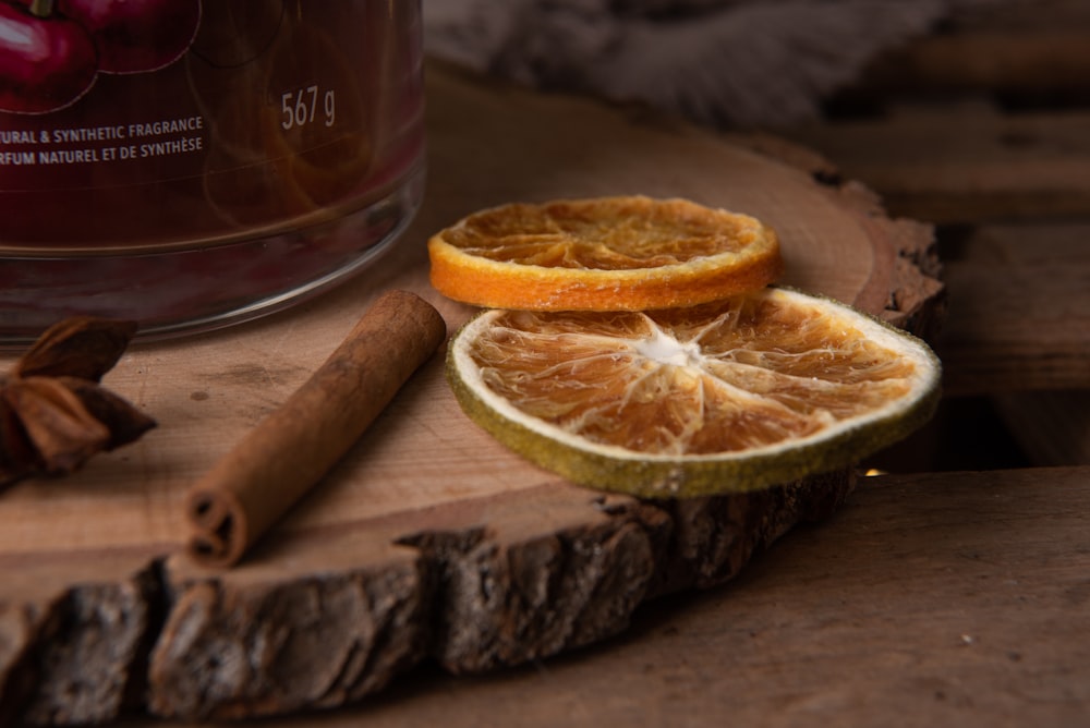 an orange cut in half sitting on top of a piece of wood