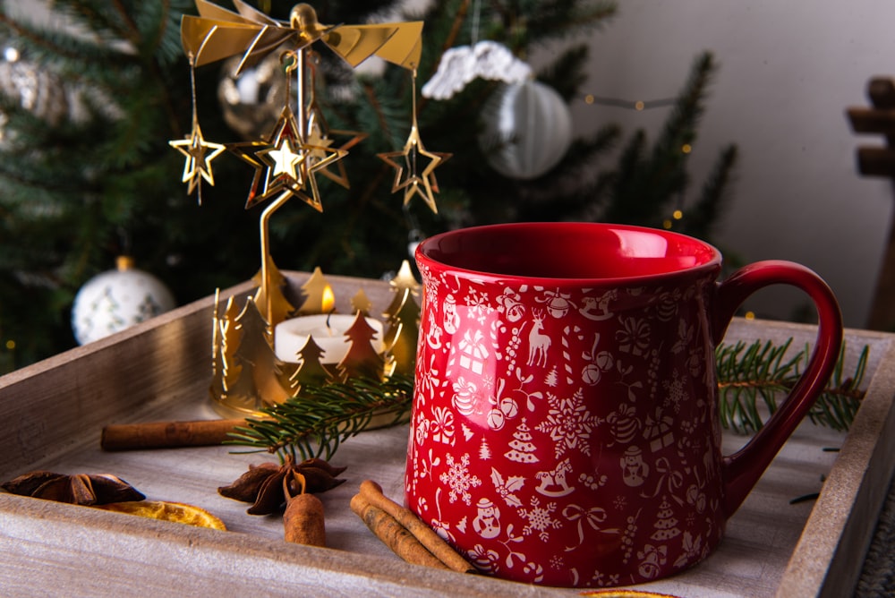 a red mug sitting on top of a wooden tray