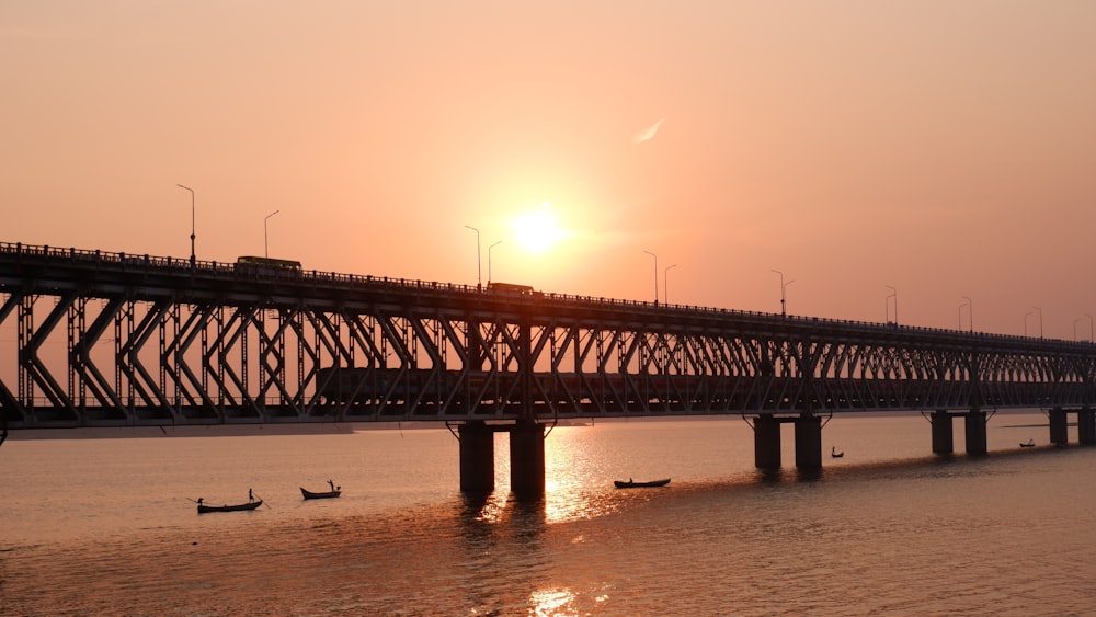 eine Brücke über ein Gewässer bei Sonnenuntergang