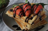 a stack of waffles with chocolate drizzled on top