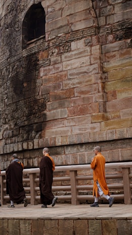 a group of monks walking on a bridge