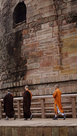 a group of monks walking on a bridge