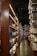 A cozy, dimly lit bookstore corridor lined with tall wooden shelves filled with a variety of books. The polished concrete floor reflects the soft light, creating a warm and inviting atmosphere. Books of different sizes and colors are neatly arranged, inviting exploration and discovery.