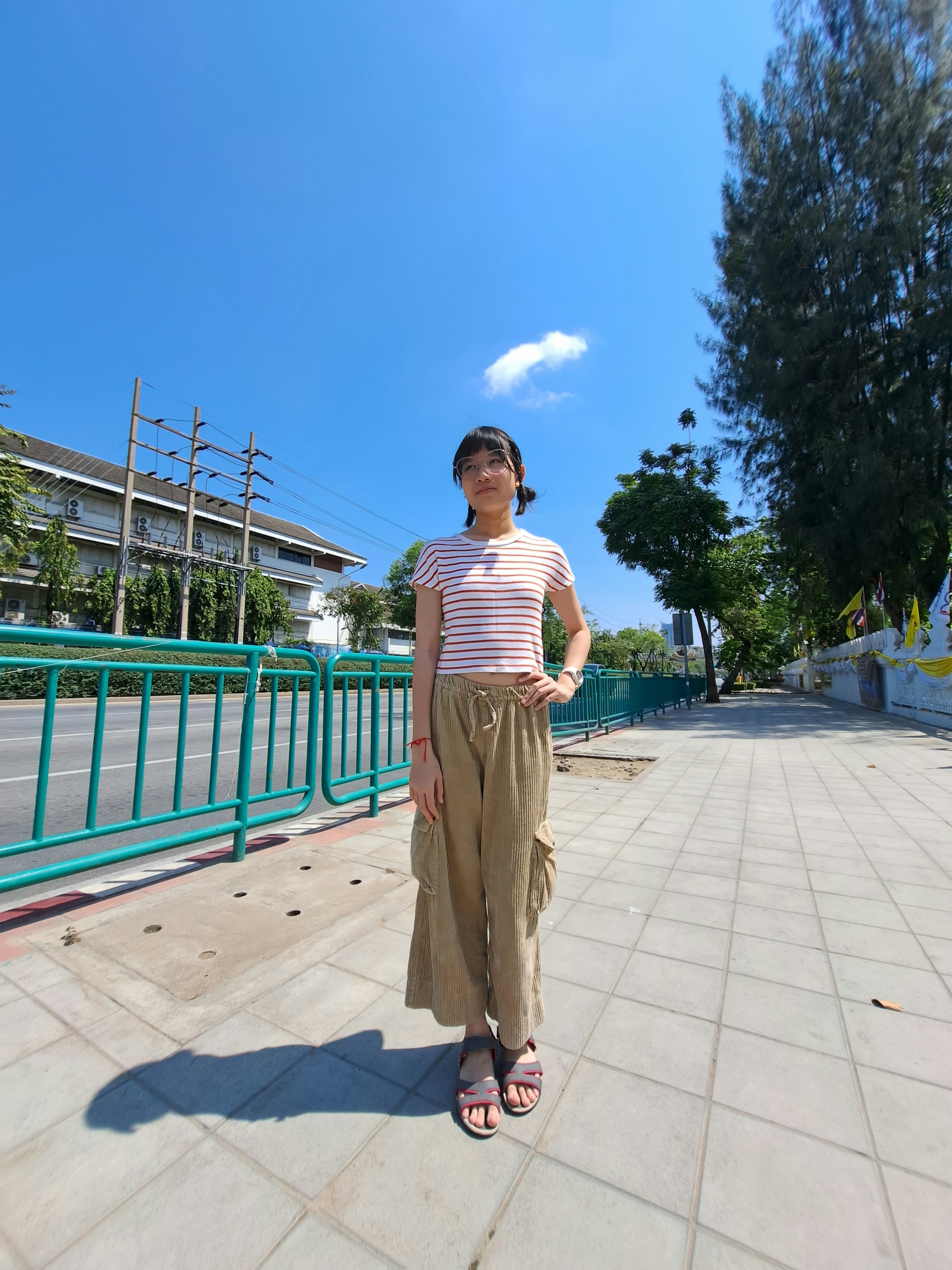 A woman standing on a sidewalk with her hands on her hips photo – Free ...