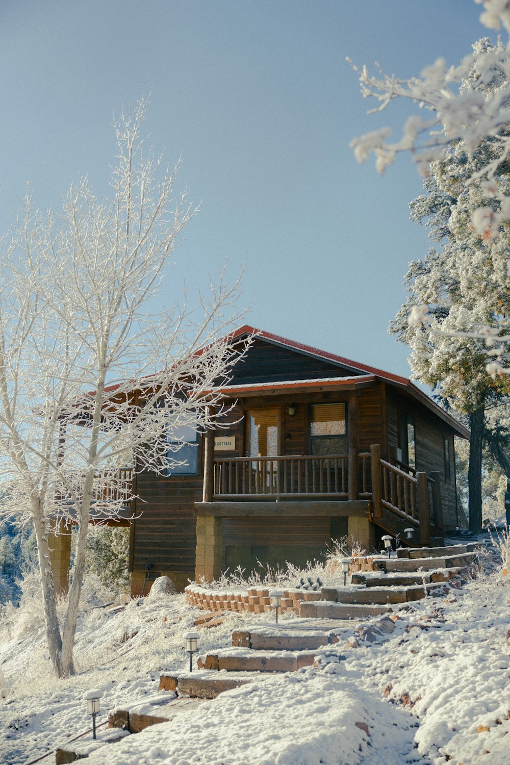 a cabin in the snow with steps leading up to it