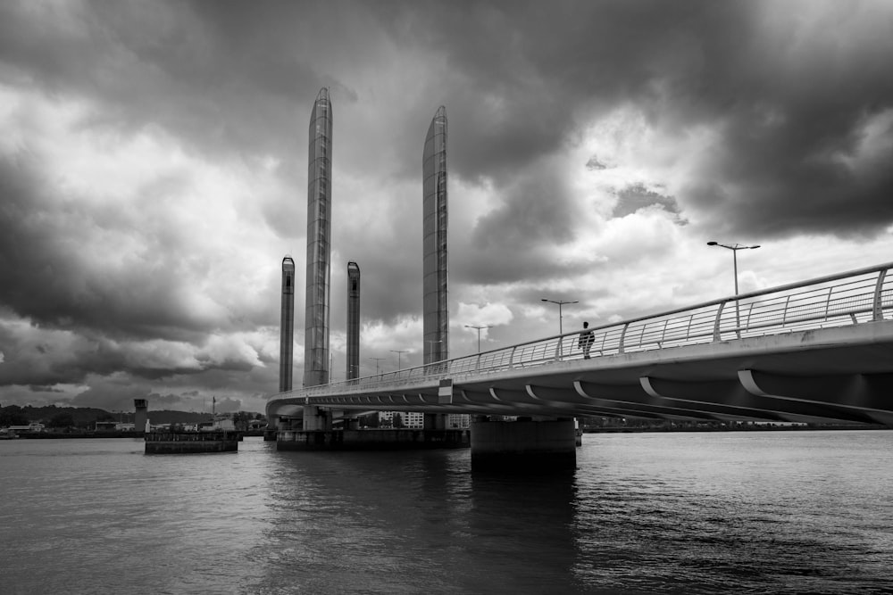 a black and white photo of a bridge over water