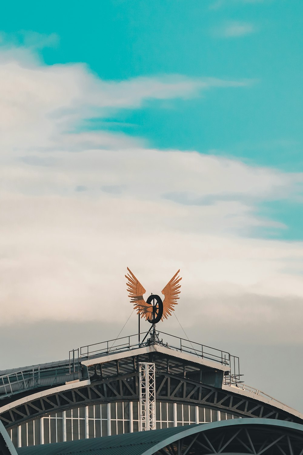 una gran estatua de pájaro en lo alto de un puente
