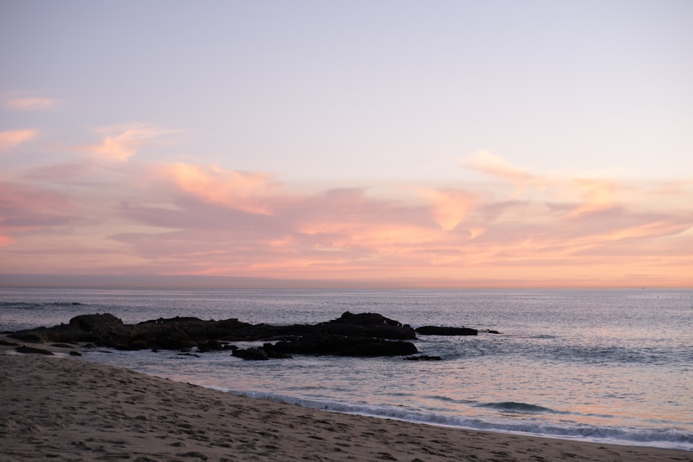 a sandy beach with a body of water in the distance