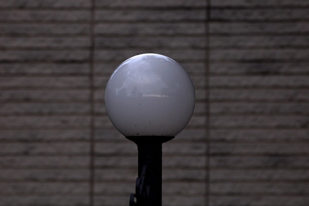 a street light in front of a brick wall