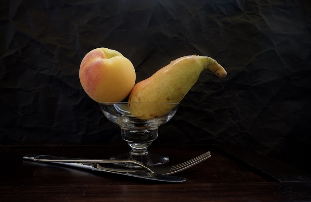 a glass bowl with two pieces of fruit in it