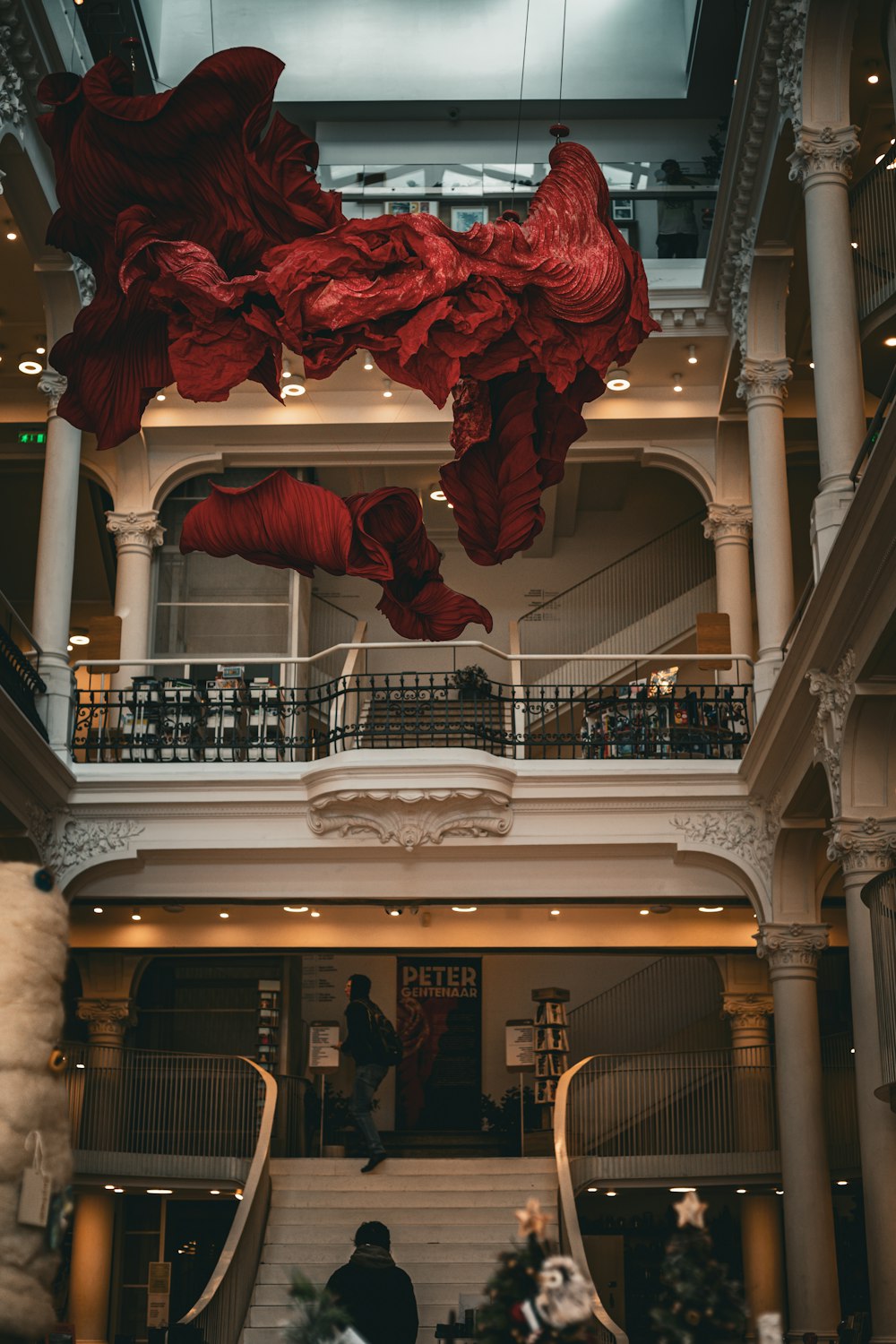 a large red sculpture hanging from the ceiling of a building