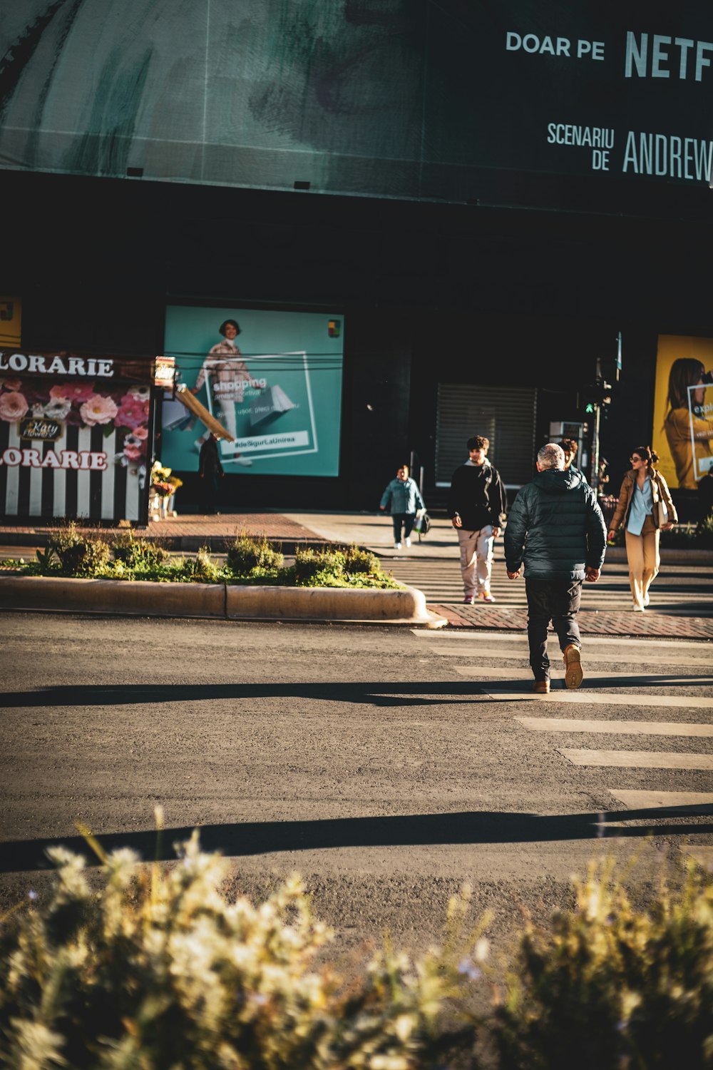 a group of people walking across a street