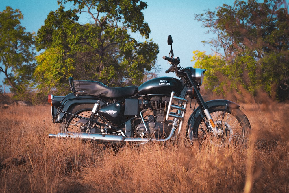 a motorcycle parked in a field of tall grass