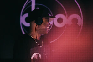 A happy person wearing headphones, enjoying music with a visible play icon on the device.