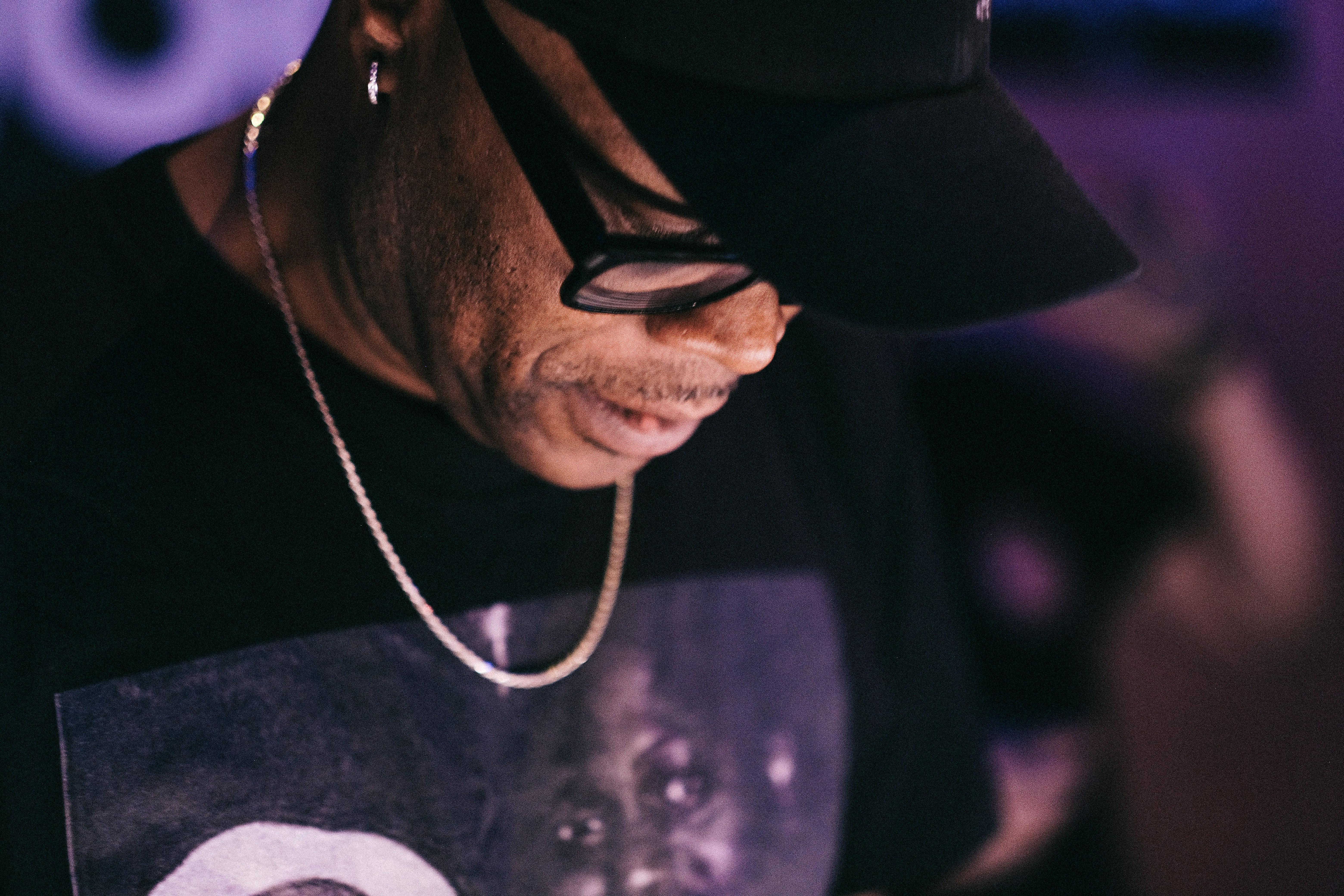 um homem de chapéu e óculos olhando para um celular