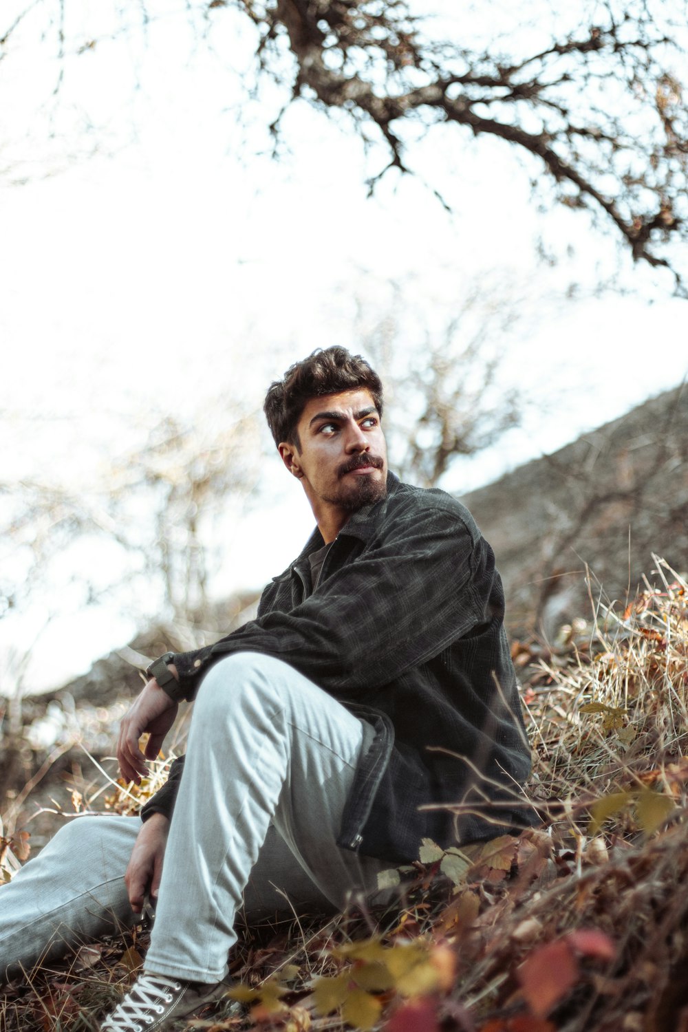 a man sitting on the ground in a field