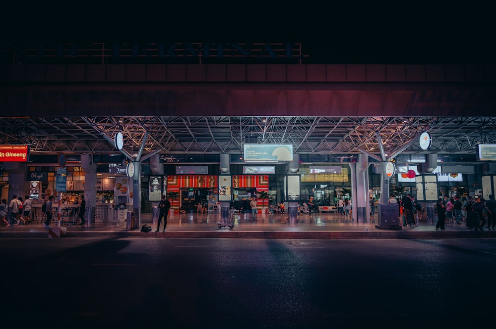 a group of people standing outside of a building at night