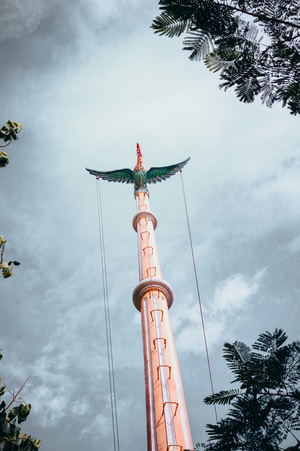 uma torre alta com um pássaro em cima dela