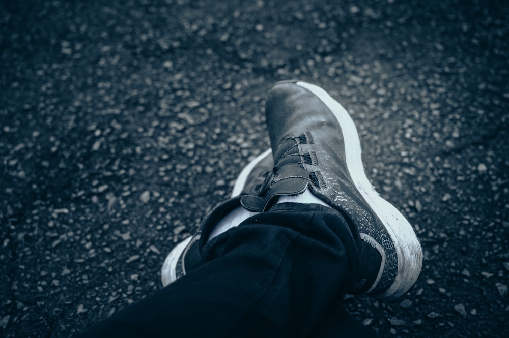 a person's feet in black and white sneakers