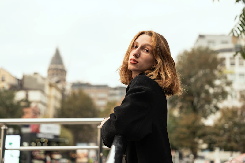 Sugar Mommy con abrigo negro mirando a la distancia