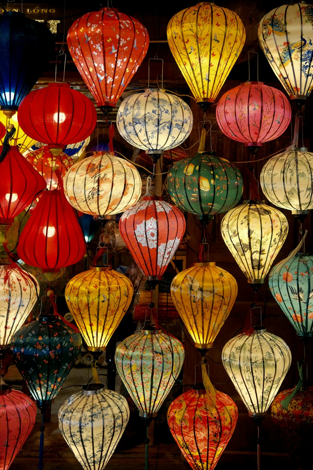 a bunch of colorful lanterns hanging from a ceiling