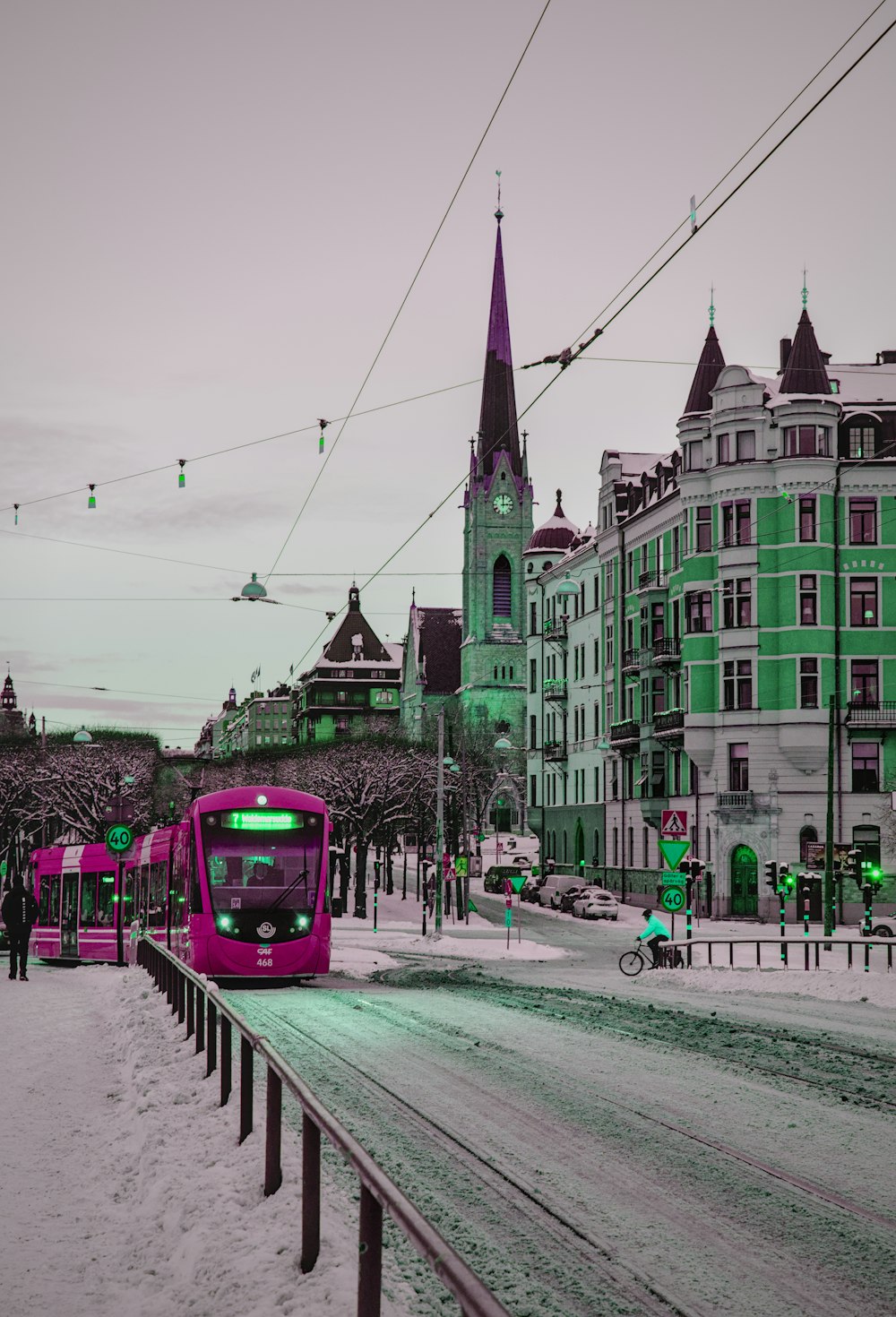 a blue train traveling down a snow covered street