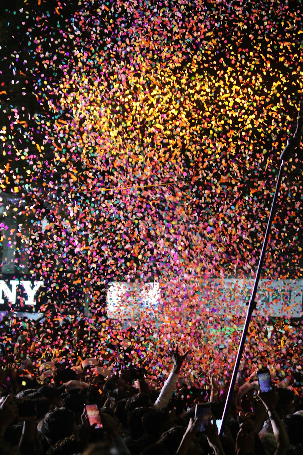 a large crowd of people at a concert with confetti in the air