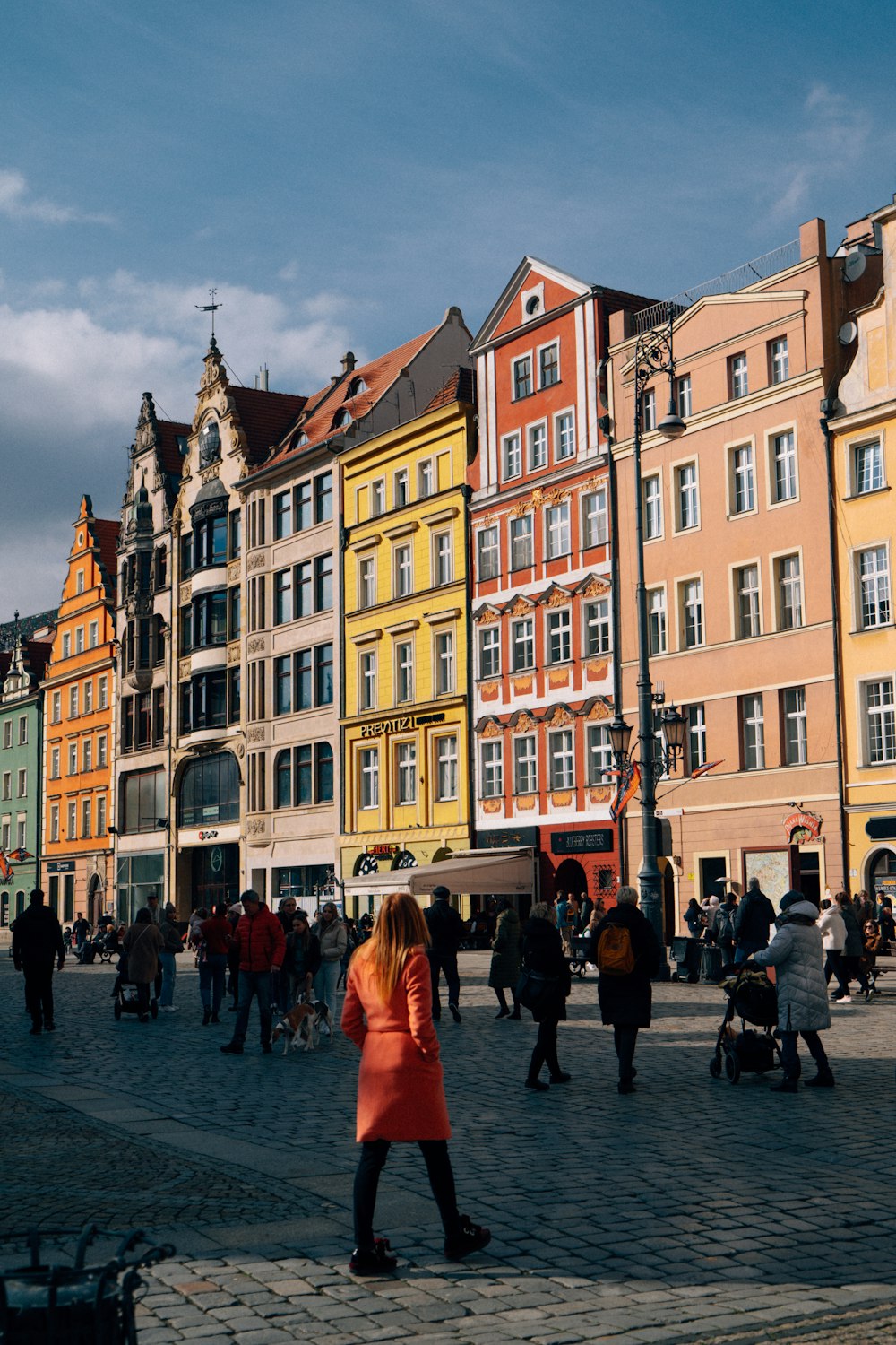 a group of people walking around a street next to tall buildings