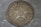 A vintage coin featuring a large star with the number 50 in the center, surrounded by decorative wreath elements. The date 1922 is inscribed below, and the word 'КОПЕЕK' is written at the top. The coin has a worn, metallic surface with visible scratches and patina.