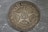 A vintage coin featuring a large star with the number 50 in the center, surrounded by decorative wreath elements. The date 1922 is inscribed below, and the word 'КОПЕЕK' is written at the top. The coin has a worn, metallic surface with visible scratches and patina.