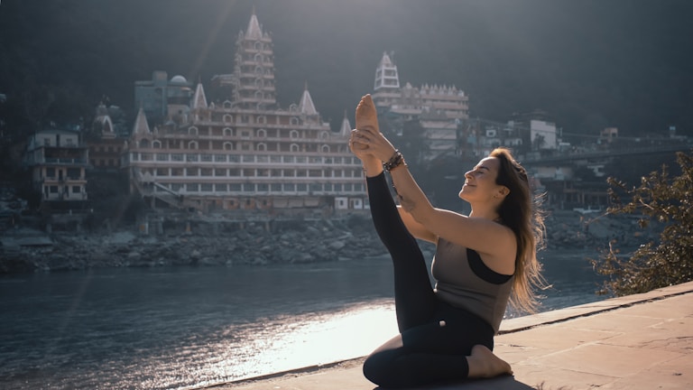 a woman is doing yoga in Rishikesh