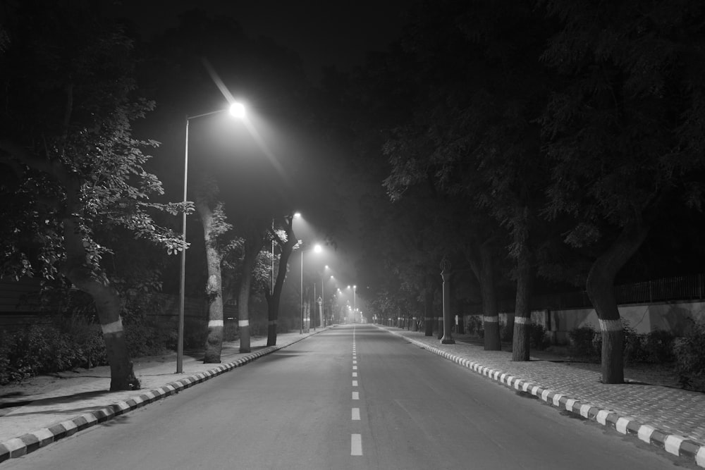 a black and white photo of a street at night