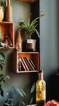 Close-up of unique home decor items in matte military green tones arranged stylishly on a shelf.