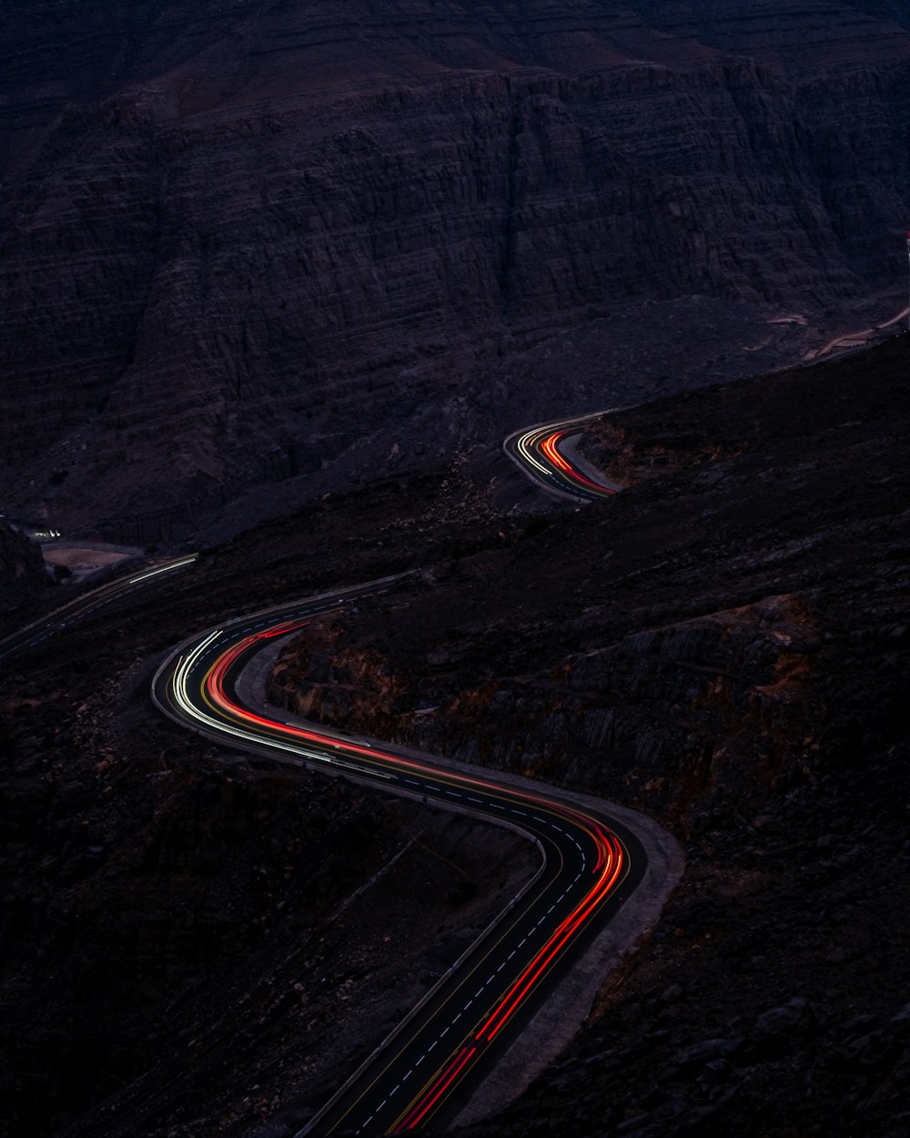 Un camino sinuoso en las montañas por la noche