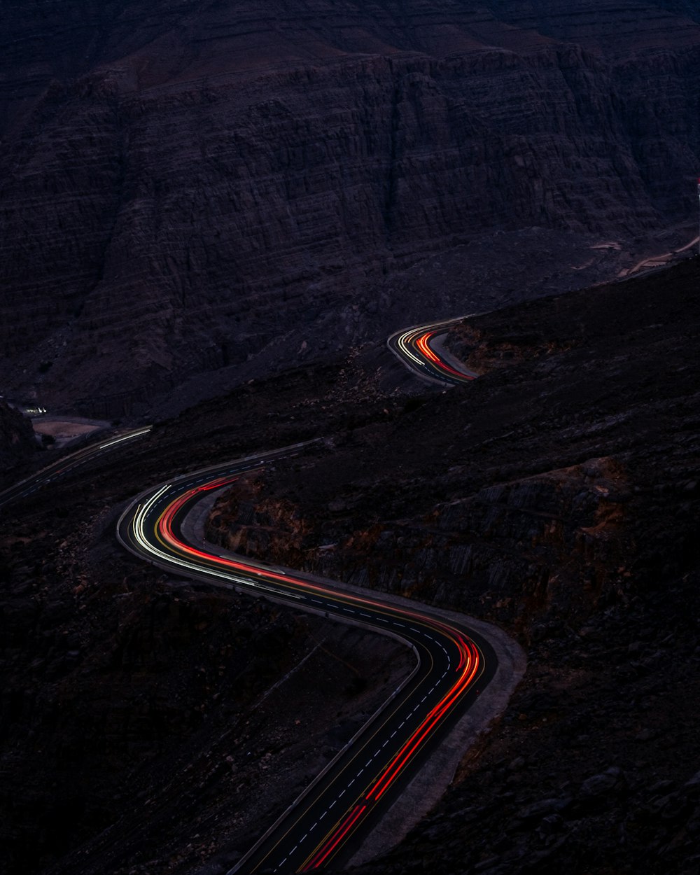 Una strada tortuosa tra le montagne di notte