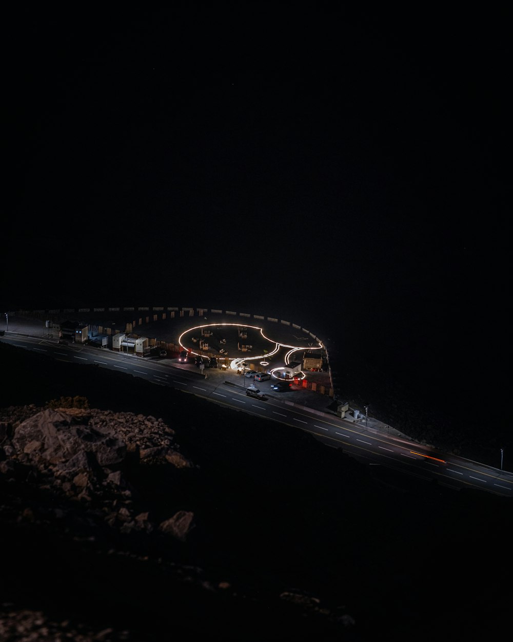 a night time view of a highway with a bridge in the background