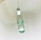 A clear glass bottle standing upright in a white sink as water flows into it from above. The bottle is partially filled with water, and reflections from the glass create gentle ripples on the surface.