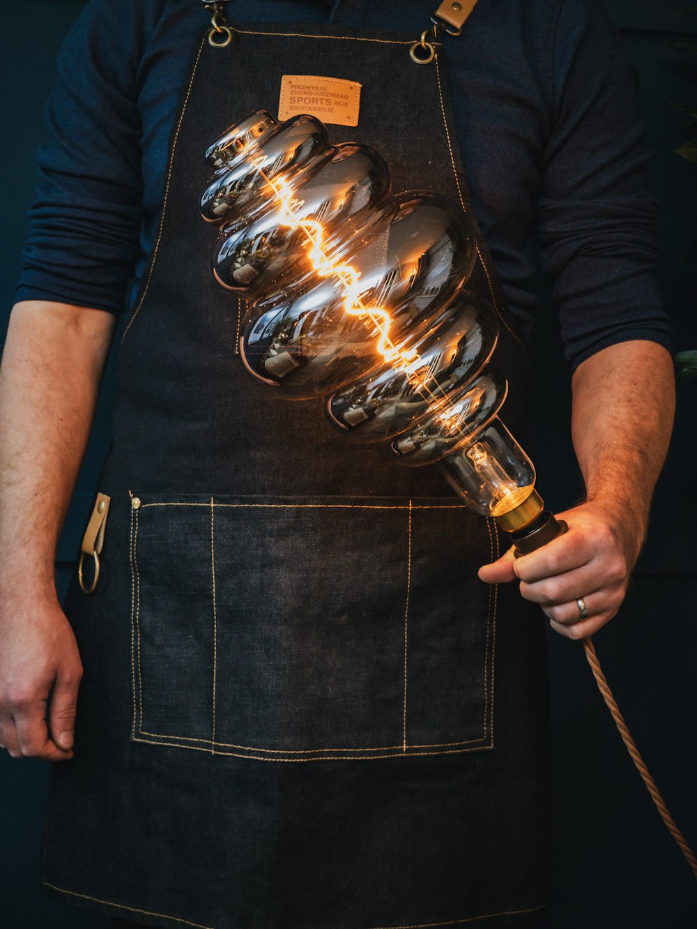 a person wearing an apron holding a light bulb