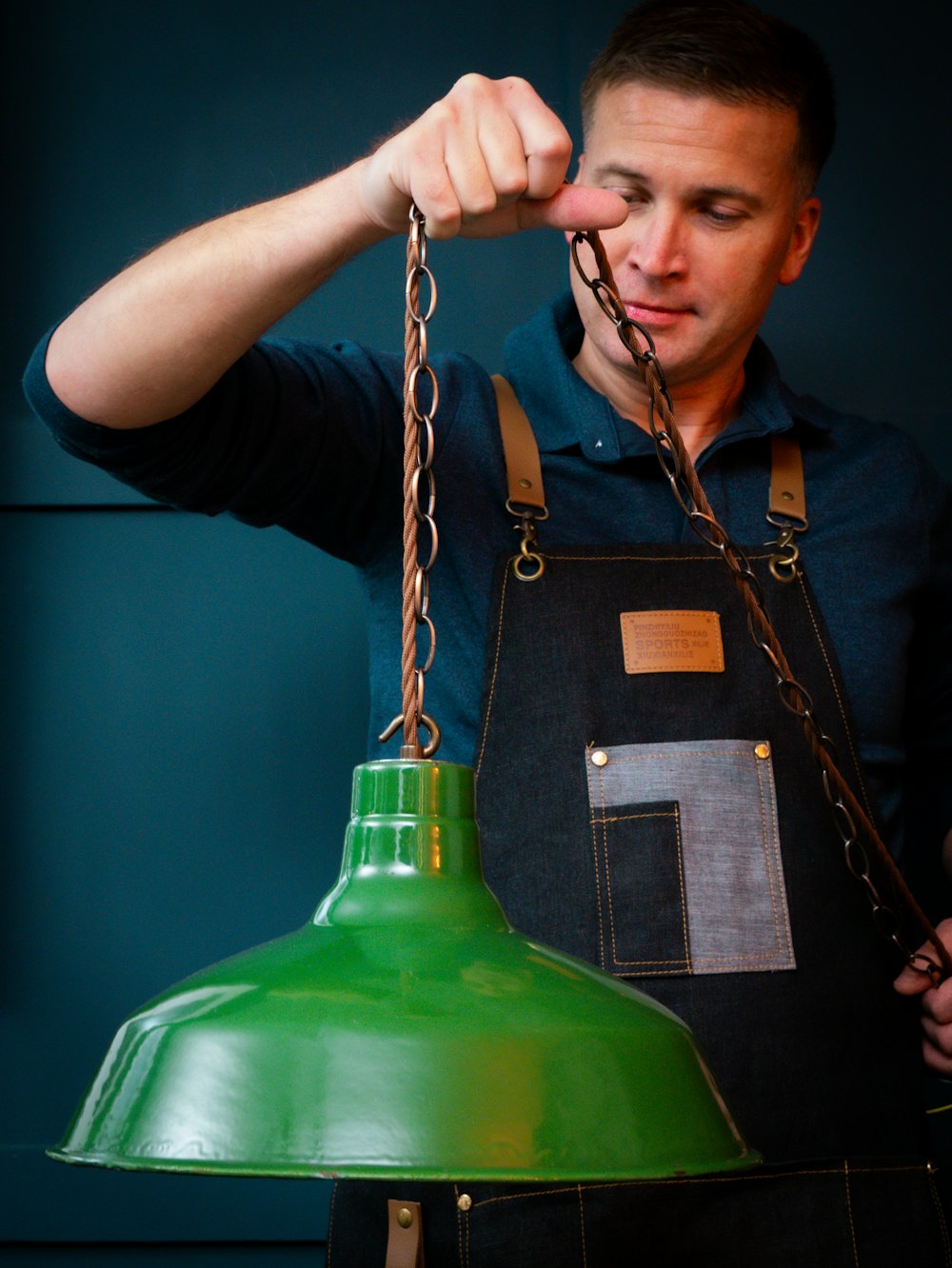 a man wearing an apron and holding a green light