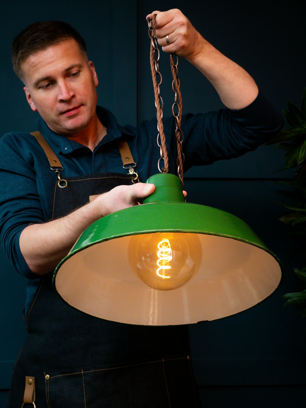 a man is holding a green light bulb