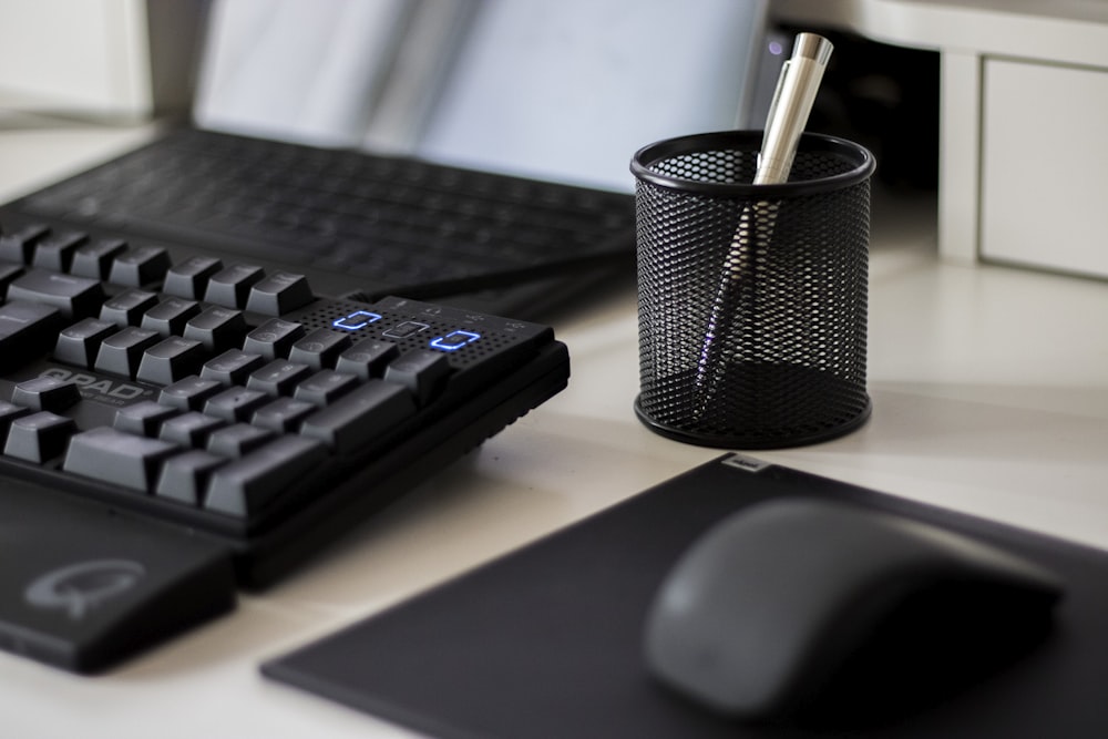 a computer keyboard and a mouse on a desk