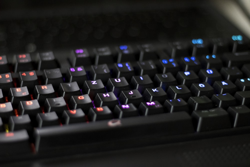 a close up of a black keyboard with red and blue keys