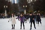 A group of women skaters holding hands in solidarity on the ice.
