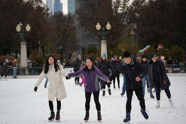 A group of women skaters holding hands in a circle, celebrating after a practice session.
