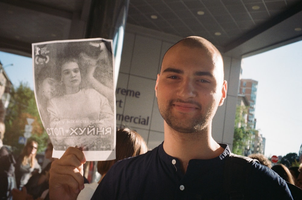 a man holding up a paper with a picture of a woman on it