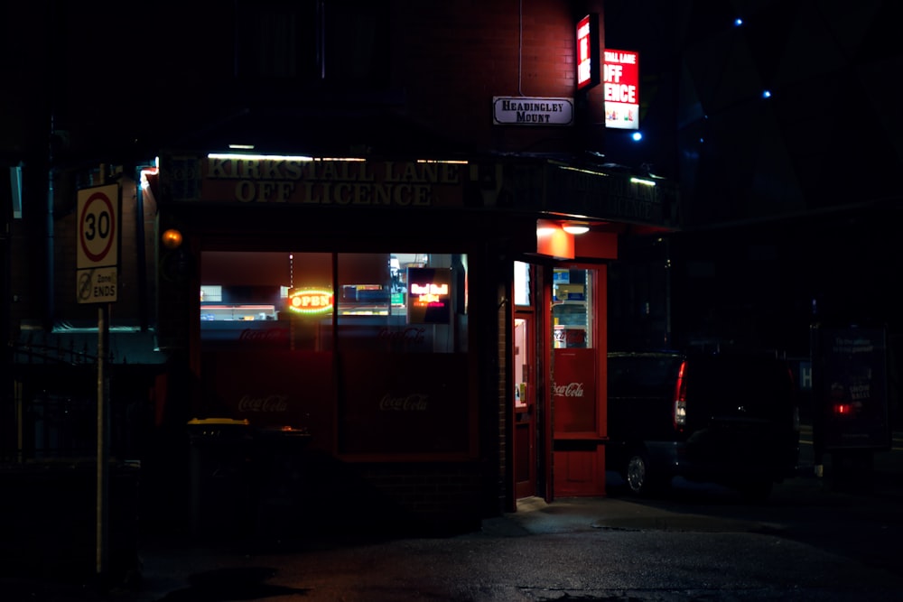 a red telephone booth sitting on the side of a road