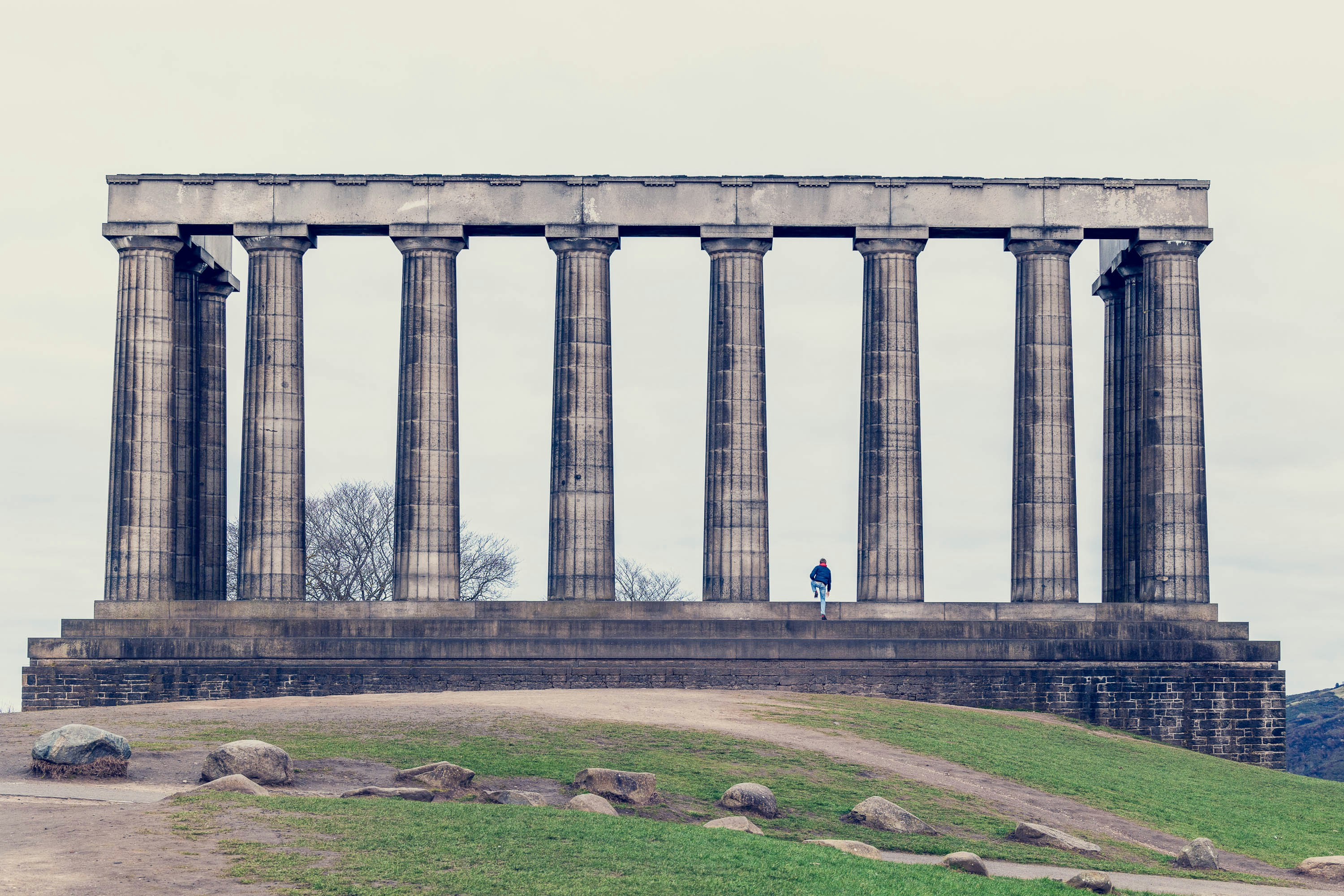 a person standing in front of a large stone structure