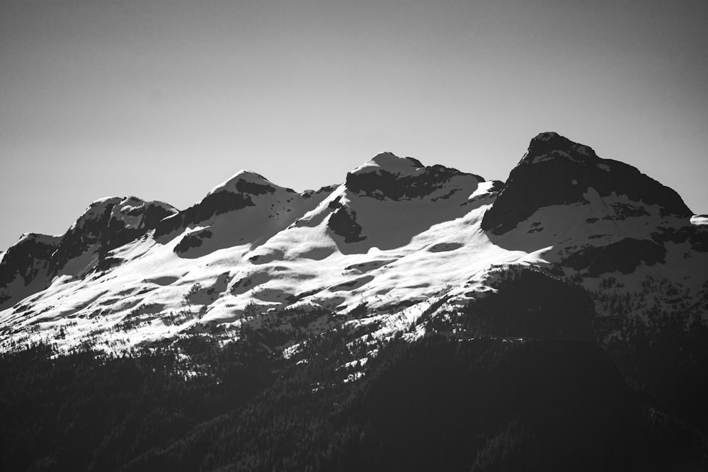 a black and white photo of snow covered mountains